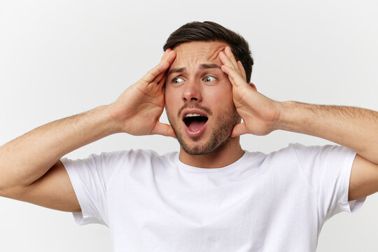 Shocked excited confused tanned handsome man in basic t-shirt touch head open mouth posing isolated on over white studio background. Copy space Banner Mockup. People emotions Lifestyle concept