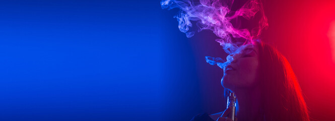 Close up banner portrait of vaping girl in neon blue and red light - copy space