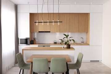 Scandinavian style cozy modern white kitchen interior with a dining zone, white modern interior in...