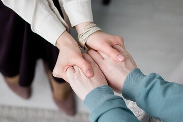A woman psychologist holds the hands of the patient and holds the hand and listens. Patient...
