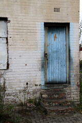 A picture of a very old colorful wooden house door at an abandoned house.