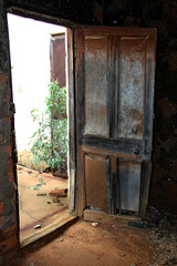 A picture of a very old colorful wooden house door at an abandoned house.