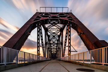 The Big Four Bridge that connected Kentucky and Indiana is an old railroad truss bridge, originally built in 1895, and was converted into a path for people to cross the Ohio River. Long exposure. - obrazy, fototapety, plakaty