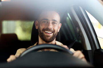 Handsome smiling latin man driving a car. Car sharing concept 