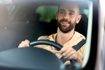 Handsome confident latin man driving a car on the road. Seat belt, safety driving concept