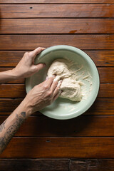 Women's hands kneading natural yeast bread dough