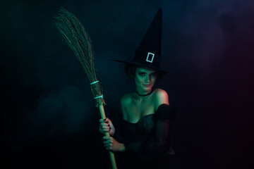 Photo of satanic tempting lady enjoy nightmare magic holding broom stick isolated on black dark colored background