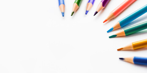 Horizontal banner with colored watercolour pencils and copy space on white background. School supplies. Kid's stationery. Back to school backdrop.