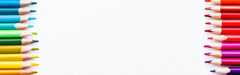 Rows of colored pencils on white background. School supplies with copy space on white background. Top view on kid's stationery. Back to school backdrop.