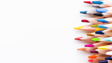 Horizontal row of colored pencils. Copy space on white background. School supplies. Kid's stationery. Back to school backdrop.