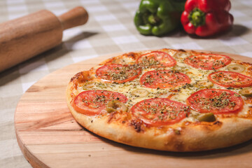 Detail view of a Neapolitan pizza on a table with a checkered tablecloth.