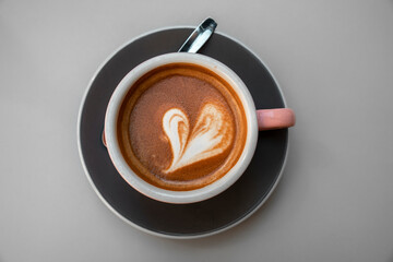 Close up on a cup of a hot coffee with a latte art heart design at a cafe in San Sebastian, Basque Country, Spain