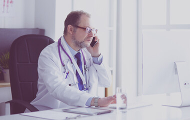 Portrait of senior doctor in office sitting at the desk