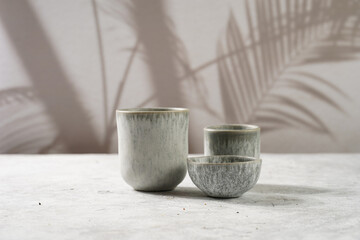 empty grey ceramic espresso and coffee mugs, dip bowl on a grey background
