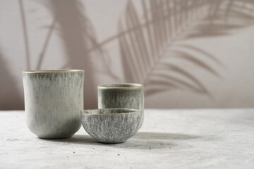 empty grey ceramic espresso and coffee mugs, dip bowl on a grey background