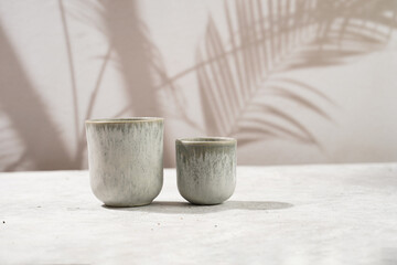 empty grey ceramic espresso and coffee mugs on a grey background