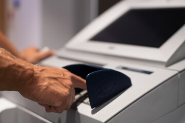 Mann gibt Pin am Bankautomaten ein 