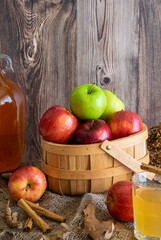 A basket of autumn harvest apples against in an autumn theme against a warm wood background