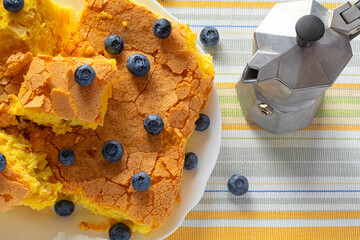 handmade sponge cake or sponge biscuit with blueberries on white ceramic plate.