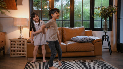 Family concept of 4k Resolution. Asian children dance together happily in the living room.
