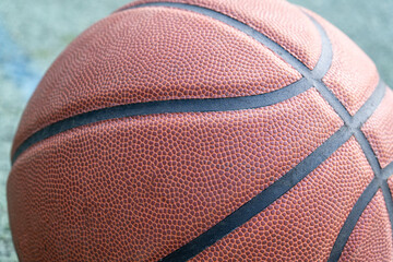 Obraz premium Orange basketball ball on the ground. Close-up ball on the red court. Basketball on the street or indoor court. Sports gear without people. Minimalism. Template, sport background 