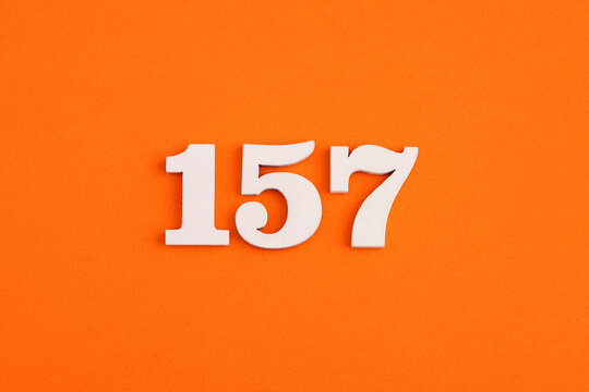 White wooden number 157 on eva rubber orange background Stock
