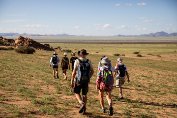 hikers in the namibia desert towards the mountains