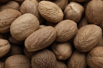 Heap of nutmeg seeds as background, closeup