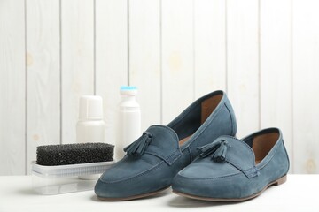 Stylish footwear with shoe care accessories on white  table
