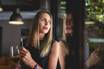 one woman with glass of red wine and electronic cigarette device