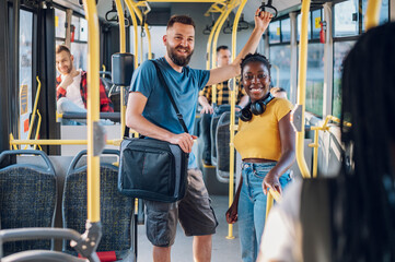 Multiracial friends talking while riding a bus in the city