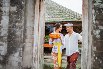 young balinese couple wearing kebaya dress and traditional balinese costume at their traditional house