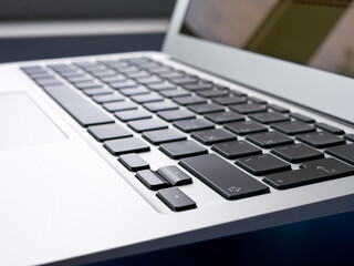 The keyboard of a modern ultra thin laptop, close-up, side view, nobody. Notebook keys shift, enter. Office work, online work.