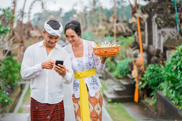 portrait of balinese couple using mobile phone together