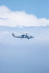 Fototapeta na wymiar Military Helicopter flying in the air, clouds