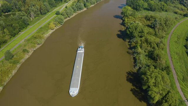 Drone flying over barge which is navigating waters on the Schelde in Belgium