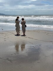 Two young women with elegant clothing enjoying the beach in Kamakura with bare feet