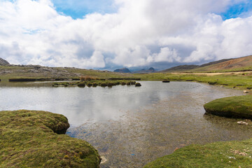 lagoon reflecting the sky full of clouds in the peruvian andes mountain range