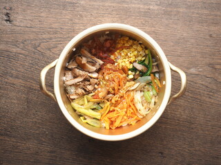 bowl of Bibimbap, Korean mixed rice with assorted vegetables and meat, on wooden background