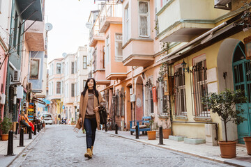 beautiful woman walking in balat turkey full of colorful house