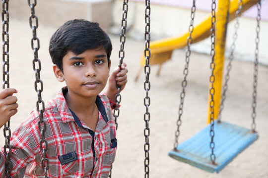 Indian Cute Boy Playing On Swing