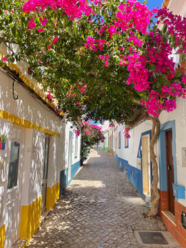 Narrow street in Ferragudo, Algarve Portugal. Bougainvillea. Colourful houses. Landmark.