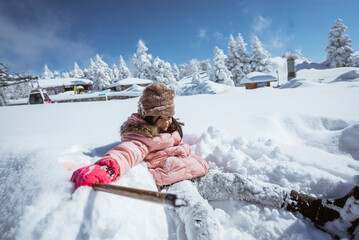 happy little girl playing outside in the snow with clear sky