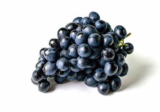 big bunch of sweet fruit black grapes close up white background
