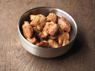 bowl of roasted pork meat on wooden table