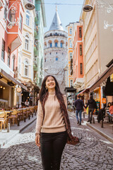woman walking through an alley full with cafe and historical building in istanbul turkey - obrazy, fototapety, plakaty