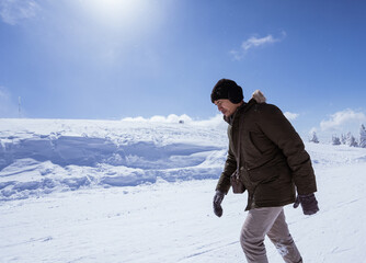 Fototapeta na wymiar portrait of a man walking on top of the snowy mountain in bursa turkey
