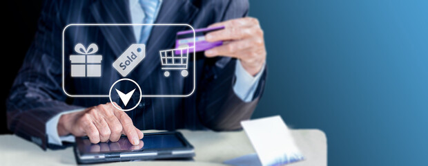 Close-up of a male businessman using a credit card to make purchases on a digital tablet.