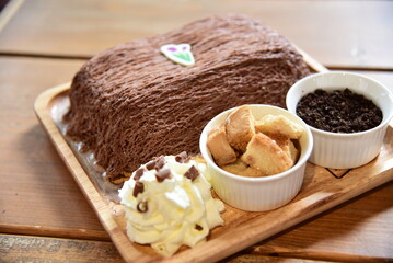 Chocolate toast with whip cream and bread icecream inside on Wood dish.