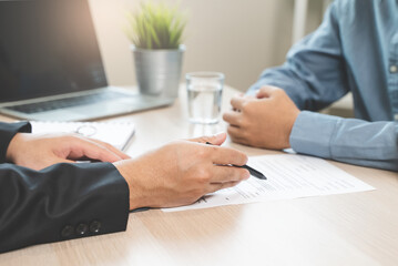 Hand of broker showing to client where to sign signature contract.